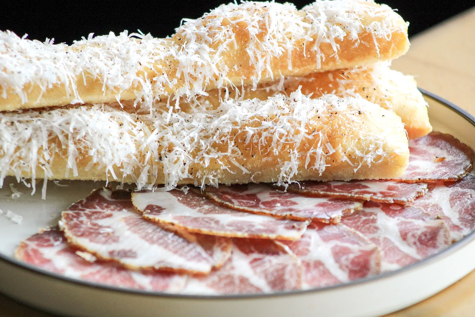 Bread, cheese and coppa on a board