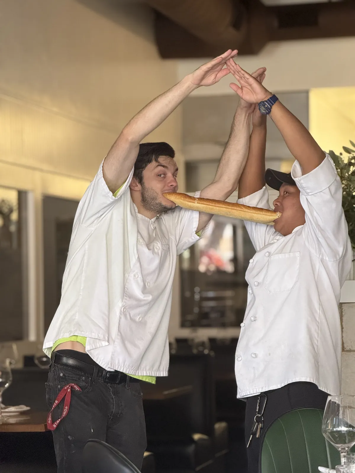 Two Vacanza Romana cooks clowning around over a shared baguette