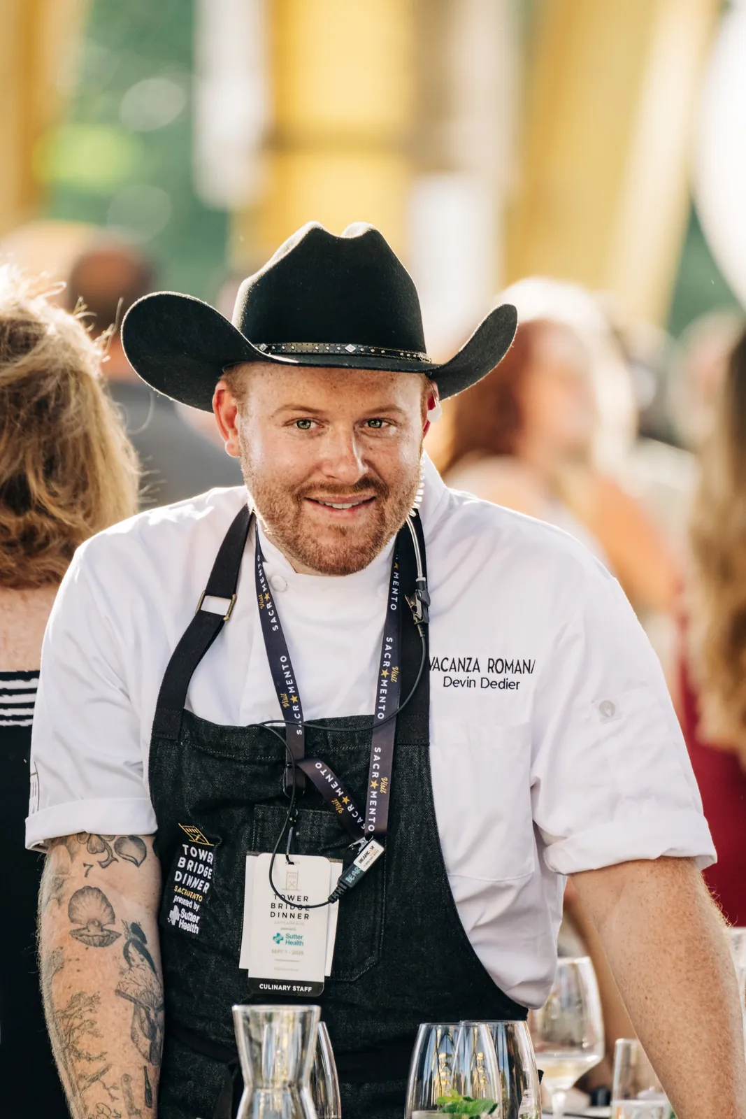 Chef Devin Dedier at the Tower Bridge Dinner, in Vacanza Romana whites and a black hat.
