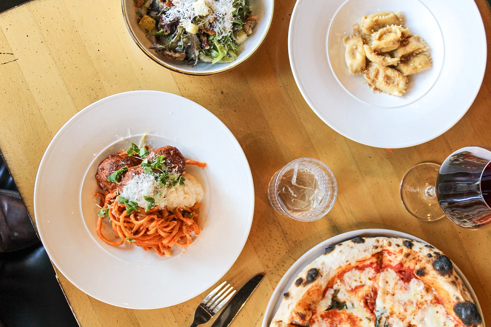 A table full of pasta, antipasti and wine