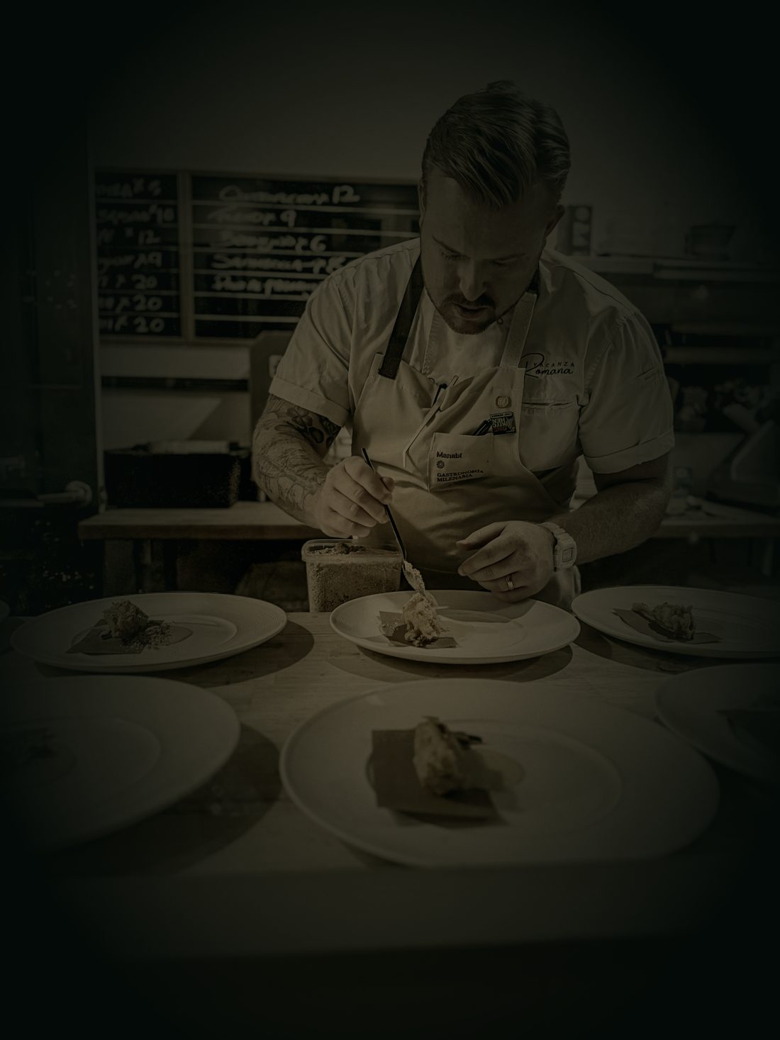 Chef Devin plating a course in low candlelight.
